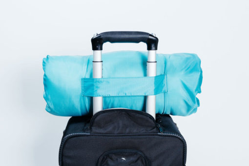 Travel pillow bag slips onto luggage
